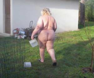 granjero grueso está alimentando a los pollos en ella desnuda